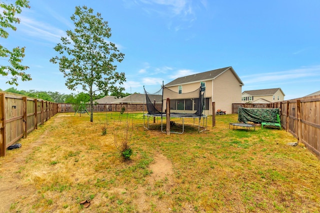 view of yard featuring a fenced backyard and a trampoline