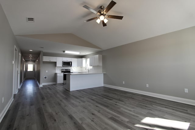 kitchen with a ceiling fan, vaulted ceiling, open floor plan, stainless steel appliances, and white cabinetry