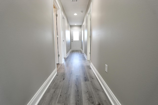 hallway with recessed lighting, baseboards, visible vents, and wood finished floors