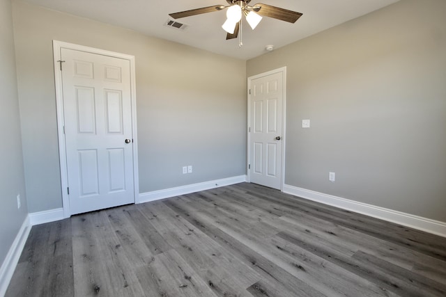 unfurnished bedroom featuring visible vents, baseboards, ceiling fan, and wood finished floors