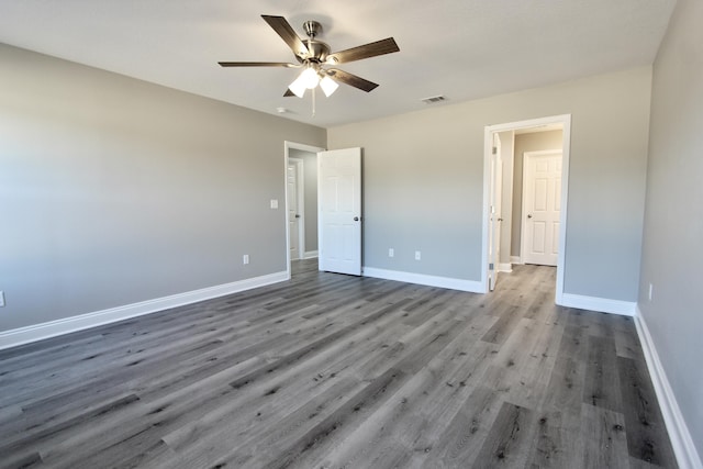 unfurnished bedroom featuring baseboards, a ceiling fan, wood finished floors, and visible vents