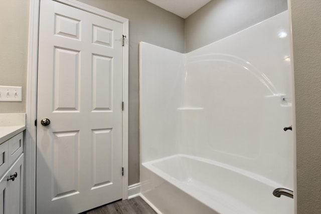 bathroom featuring vanity, wood finished floors, and bathtub / shower combination