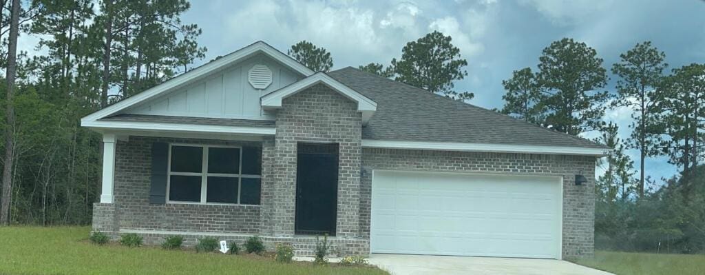 6620 Spyglass Hill Rd, Laurel Hill, FL 32567 - view of front of house featuring brick siding, a garage, board and batten siding, and concrete driveway