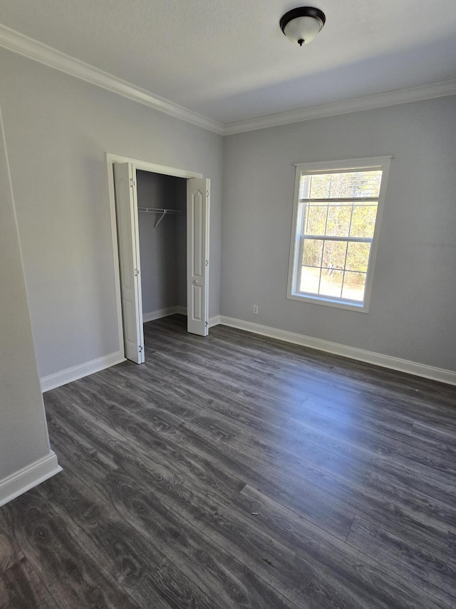467 N County Highway 395, Santa Rosa Beach, FL 32459 - unfurnished bedroom featuring dark wood-style flooring, baseboards, ornamental molding, and a closet
