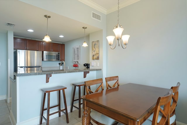 dining room with visible vents, crown molding, and light tile patterned flooring