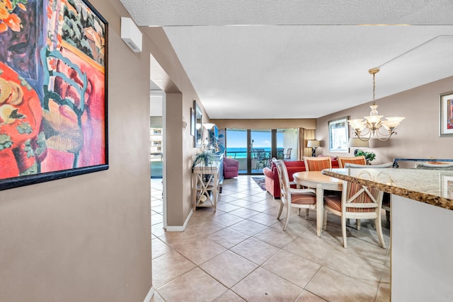 dining space featuring a chandelier, light tile patterned floors, and baseboards