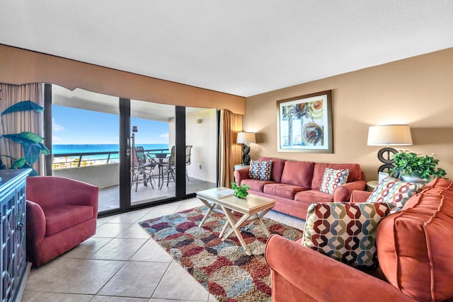 living area with tile patterned flooring and a water view