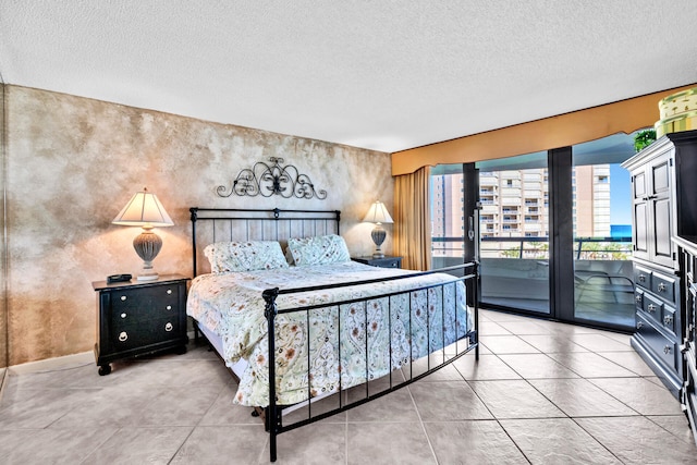 bedroom with access to outside, a textured ceiling, and light tile patterned flooring