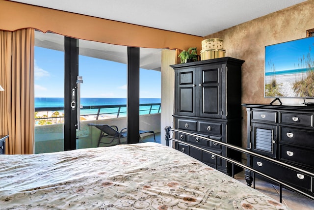 bedroom featuring view of water and beach