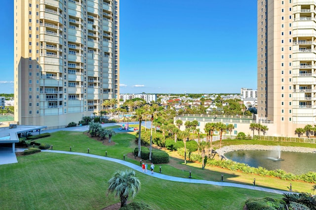 surrounding community featuring a water view and a lawn