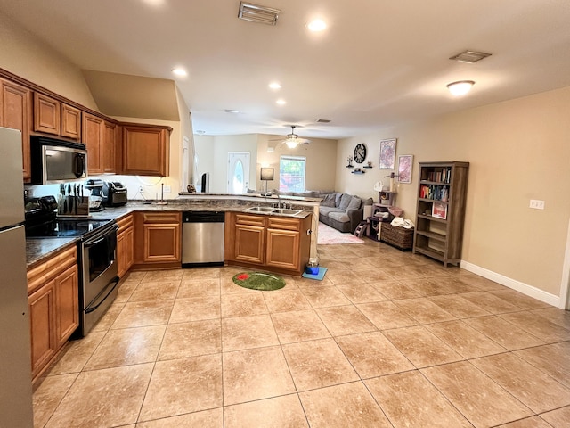 829 Fairview Dr Unit 1, Fort Walton Beach, FL 32548 - kitchen featuring stainless steel appliances, open floor plan, a peninsula, dark countertops, and brown cabinetry