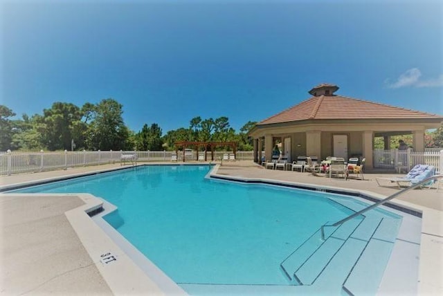 674 Emerald Bay Dr, Destin, FL 32541 - community pool with a gazebo, fence, and a patio area