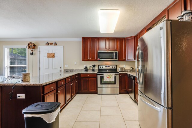 6444 Welannee Blvd, Laurel Hill, FL 32567 - kitchen featuring stainless steel appliances, dark brown cabinets, a peninsula, light stone countertops, and light tile patterned flooring