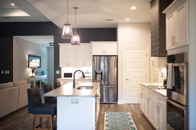 kitchen with white cabinets, dark wood-style flooring, appliances with stainless steel finishes, and a sink
