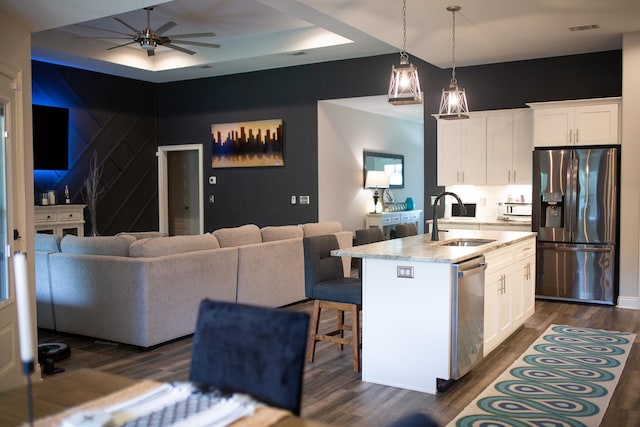 kitchen with visible vents, appliances with stainless steel finishes, a sink, dark wood-style floors, and open floor plan