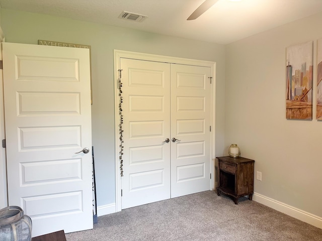carpeted bedroom with a ceiling fan, baseboards, visible vents, and a closet