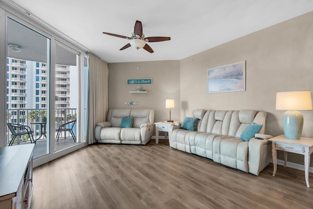living area featuring a healthy amount of sunlight, ceiling fan, and wood finished floors