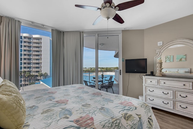 bedroom with dark wood-type flooring, a ceiling fan, and access to exterior