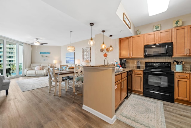 4203 Indian Bayou Trl Unit 1503, Destin, FL 32541 - kitchen with black appliances, open floor plan, decorative backsplash, a peninsula, and light stone countertops