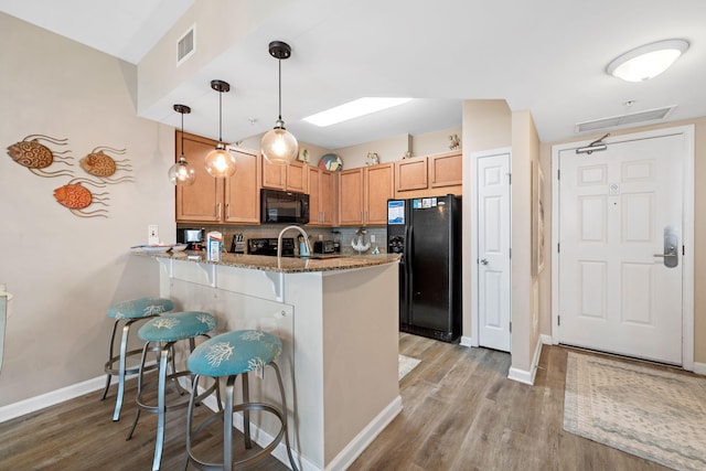 4203 Indian Bayou Trl Unit 1503, Destin, FL 32541 - kitchen with black appliances, light stone counters, a peninsula, and baseboards