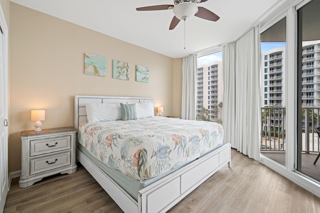 4203 Indian Bayou Trl Unit 1503, Destin, FL 32541 - bedroom featuring access to exterior, wood finished floors, expansive windows, and ceiling fan