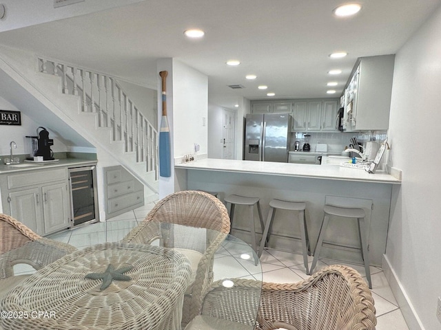 9614 Beach Blvd Unit D, Panama City Beach, FL 32408 - interior space featuring stainless steel refrigerator with ice dispenser, a sink, light countertops, beverage cooler, and light tile patterned flooring