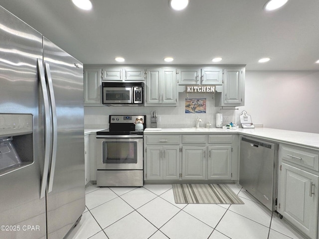 9614 Beach Blvd Unit D, Panama City Beach, FL 32408 - kitchen with appliances with stainless steel finishes, light countertops, light tile patterned floors, a peninsula, and recessed lighting