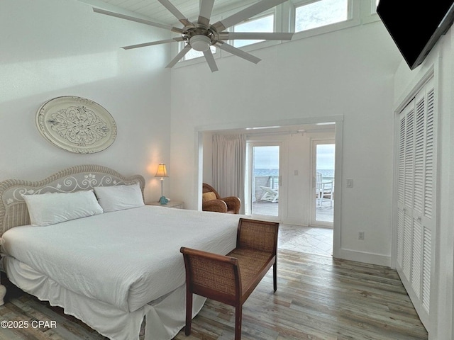 9614 Beach Blvd Unit D, Panama City Beach, FL 32408 - bedroom with high vaulted ceiling, access to outside, multiple windows, and wood finished floors