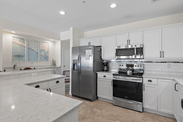 kitchen with appliances with stainless steel finishes, white cabinets, backsplash, recessed lighting, and light stone counters