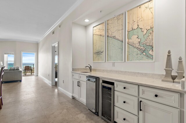 indoor bar featuring beverage cooler, crown molding, baseboards, and recessed lighting