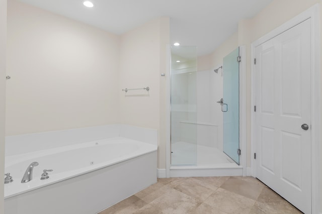 bathroom with a bath, a shower stall, and recessed lighting