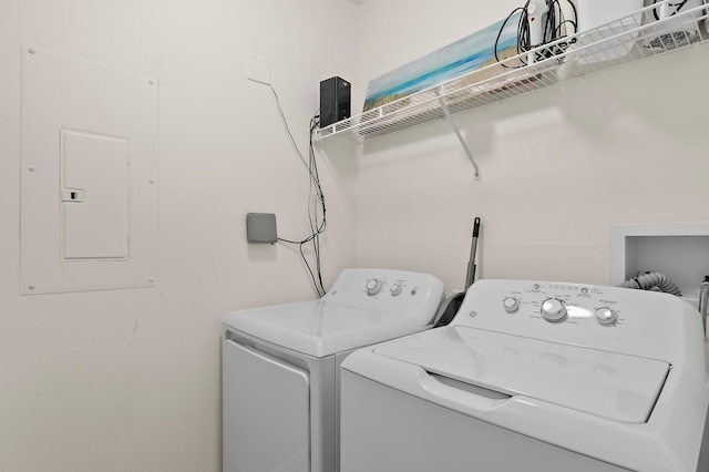 washroom with electric panel and washer and clothes dryer
