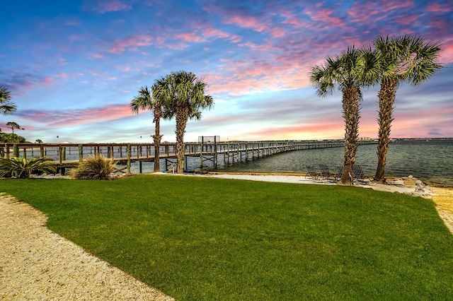 dock area with a water view and a yard