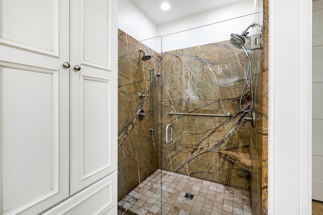 bathroom featuring a marble finish shower