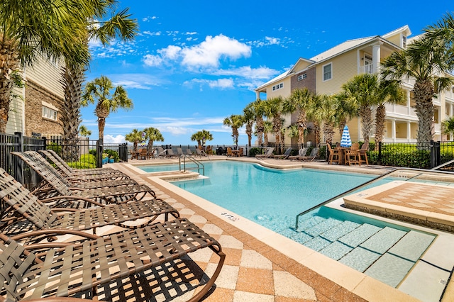 pool featuring fence, a jacuzzi, and a patio area