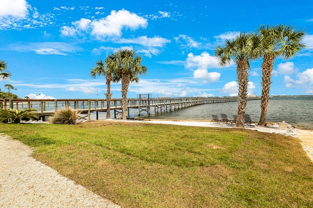 dock area with a lawn and a water view