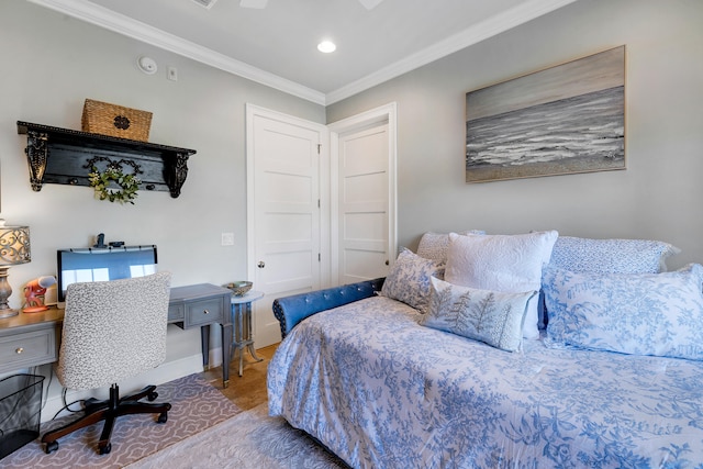 bedroom with crown molding, recessed lighting, baseboards, and wood finished floors