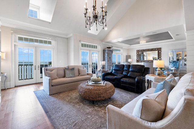 living room featuring visible vents, an inviting chandelier, wood finished floors, high vaulted ceiling, and french doors