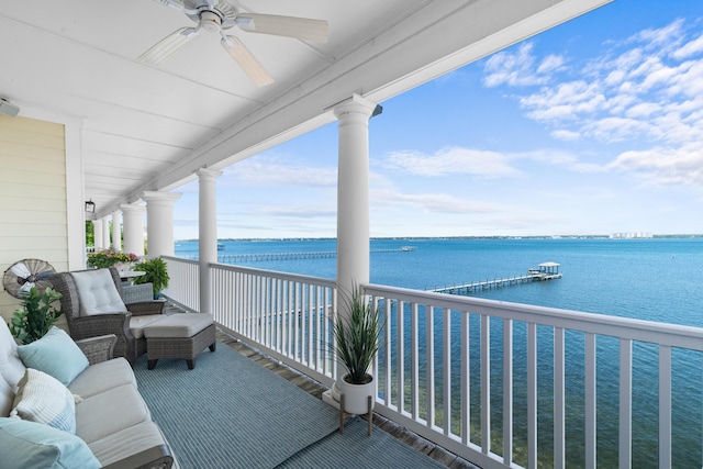 balcony with a water view and a ceiling fan