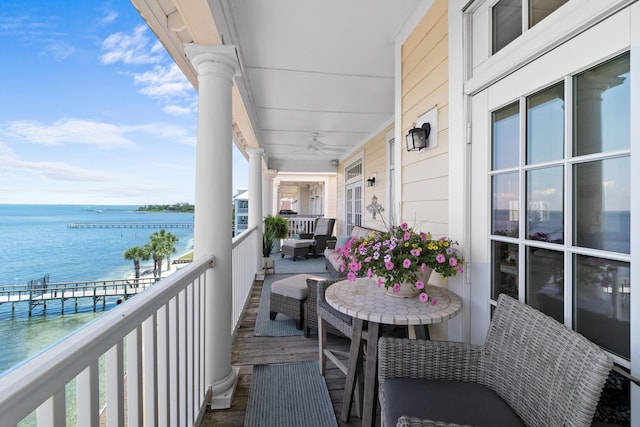 balcony with a ceiling fan and a water view