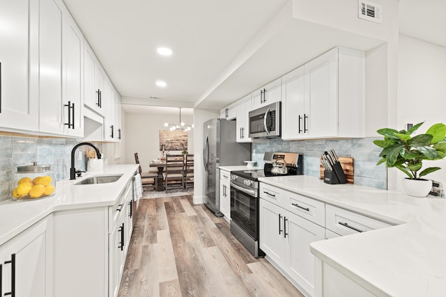 kitchen featuring a sink, decorative backsplash, stainless steel appliances, and visible vents