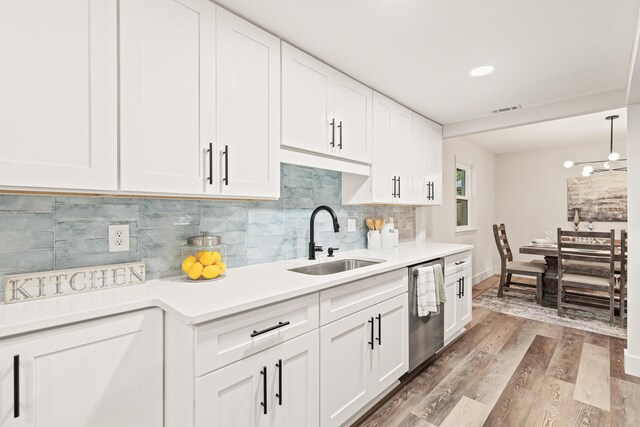kitchen with a sink, white cabinetry, light wood-style flooring, and dishwasher