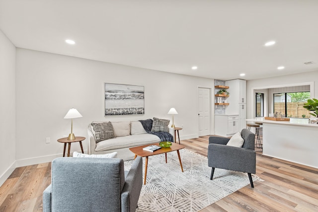 living area with recessed lighting, baseboards, visible vents, and light wood-type flooring