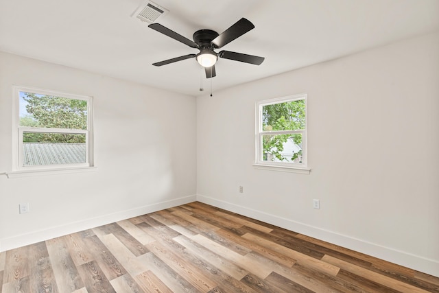 spare room featuring ceiling fan, baseboards, visible vents, and light wood-style flooring