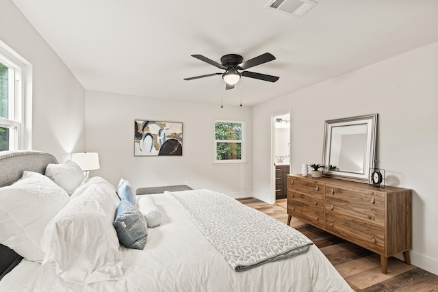 bedroom featuring visible vents, baseboards, and wood finished floors