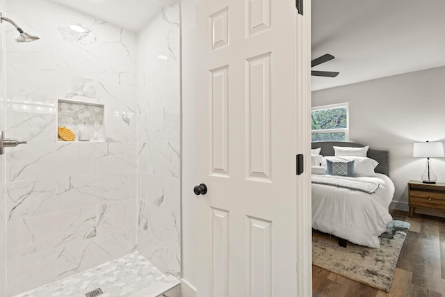 ensuite bathroom featuring a ceiling fan, a shower stall, wood finished floors, and ensuite bath