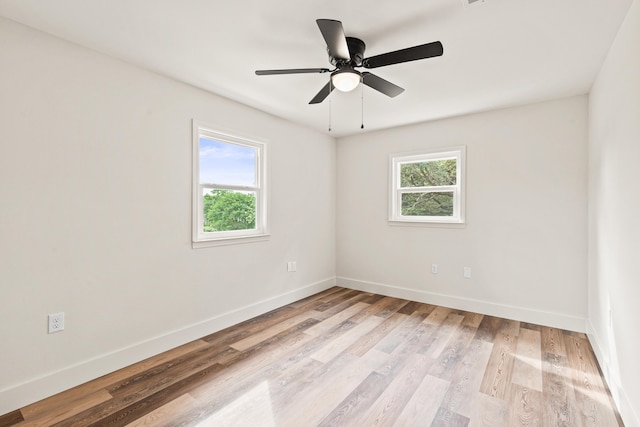 spare room with baseboards, light wood-style flooring, and ceiling fan