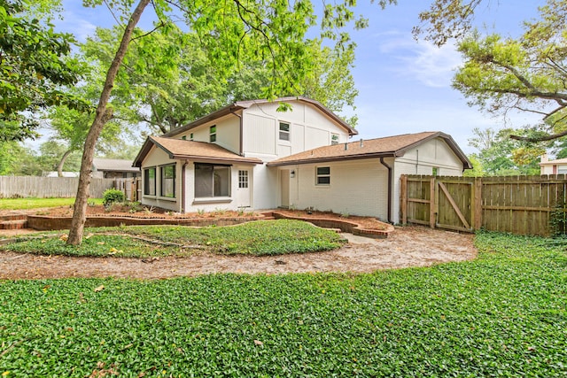 back of house featuring a sunroom, a gate, fence, and brick siding