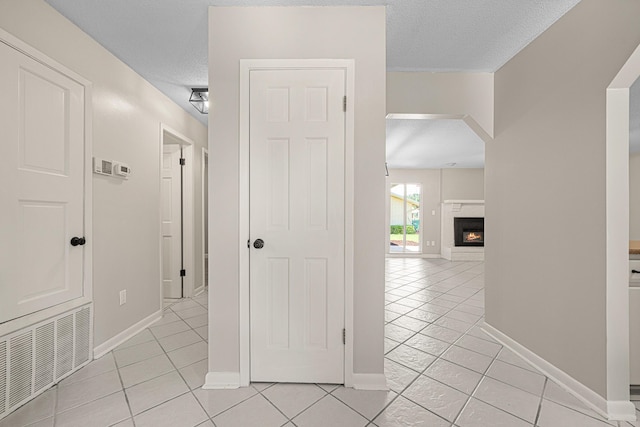 1501 Royal Palm Dr, Niceville, FL 32578 - corridor with light tile patterned flooring, a textured ceiling, baseboards, and arched walkways