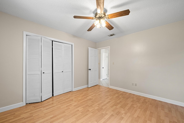 1501 Royal Palm Dr, Niceville, FL 32578 - unfurnished bedroom featuring light wood-type flooring, baseboards, a closet, and a textured ceiling